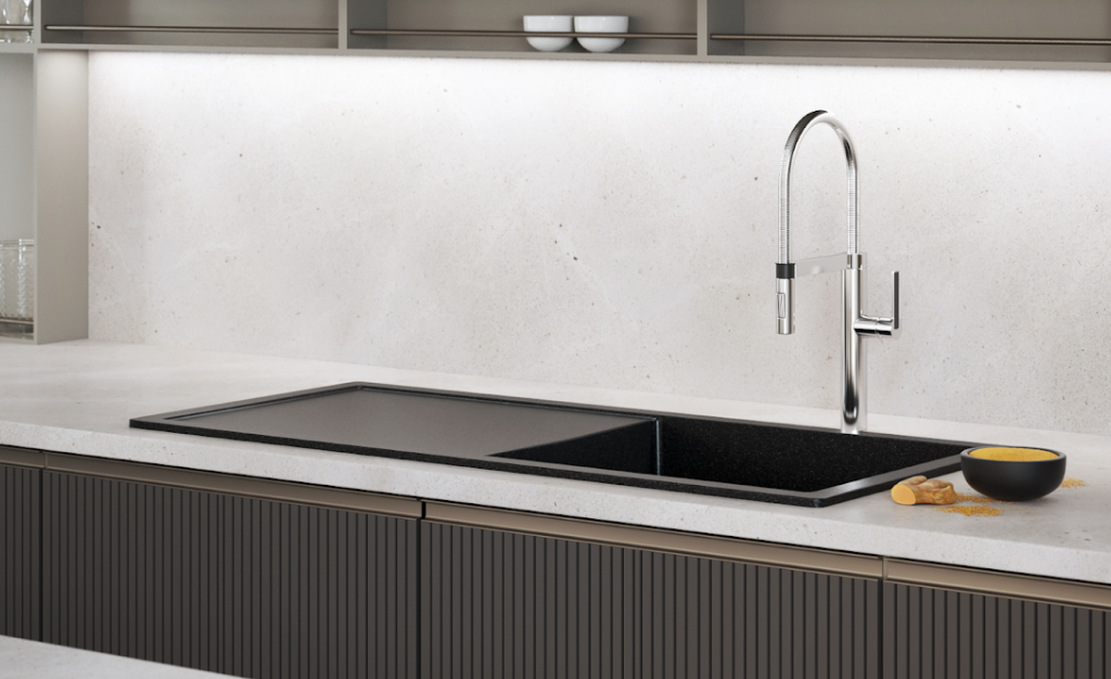 Cuba de embutir em pedra clara com torneira de aço inox em cozinha sofisticada.